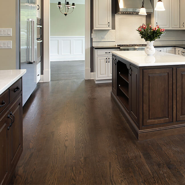 Modern kitchen with dark hardwood flooring and white cabinetry